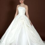Simple A-line wedding dress in satin with small fabric flower as decoration and bow on the back