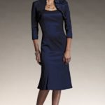 Short ceremony dress for elderly lady made in taffeta with three-quarter sleeve draped jacket decorated with a flower