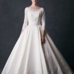 Abito da sposa classico invernale con coprispalle a bustino che si infila sopra il corpetto di scollo a V e maniche tre quarti
