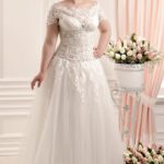 Vestido de novia talla grande con corpiño transparente colección 2021 en satèn y tul con escote barco y manga corta