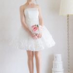 Short wedding dress with straight neckline in satin bodice and organza skirt decorated at the waist and hem with floral motifs and sparkles