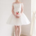 Vestido de novia mini a hombros caìdos con corpiño de encaje y falda ancha de organza con delicado diseño decorativo y desmontable en la espalda