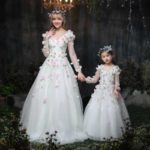 Lujosos vestidos de novia de satén y tul a juego para madre e hija con adornos florales espectaculares y mangas largas estilo princesa