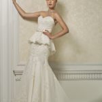 Vestido de novia sirena con corpiño de  escote corazón con un vuelo debajo de la cintura  y cinturón decorativo, cola corta.