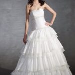 Abito da sposa con gonna svasata a più strati realizzato in raso e organza corpetto è decorato con paillettes, strass e perline