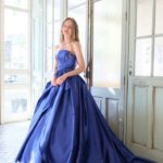 Elegant electric blue wedding dress with straight neckline, draped waist and full skirt with decorative bow and short train