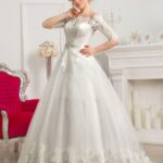 Caracas - Vestido de novia para bodas en la iglesia estilo princesa tendencias 2021 con escote humeral a hombros descubiertos y medias mangas en encaje
