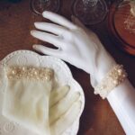 Guantes de novia color marfil hechos de tul con muchos adornos de perlas corto hasta la muñeca