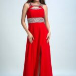 Long red evening and ceremony dress with side slit on the skirt and many decorations of rhinestones and sequins on the straps and in the belt