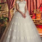 Vestido de novia princesa color marfil con busto de encaje ceñido, manga corta y falda de tul con aplicaciones de encaje