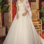 Vestido de novia tradicional de corte A con tirantes confeccionado en tul color marfil y forro de satèn color champán en el busto