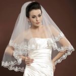 Very elegant wedding veil made of tulle and decorated on the edges with two-layer lace appliqués