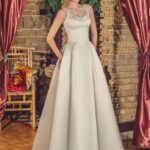 Abito da sposa con le tasche fatto in raso seta, spalline in pizzo, schiena semi scoperta stile A line
