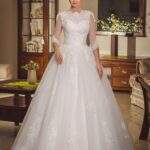 Vestido de novia clásico tradicional de encaje con una escolatura un poco alta,  manga tres cuartos y falda lineal