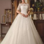 Elegant wedding dress with off-the-shoulder neckline and semi-sheer half sleeves in lace and tulle