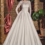 Elegante vestito da sposa invernale fatto in pizzo il corpetto con maniche lunghe e cintura in vita decorata con strass e perline