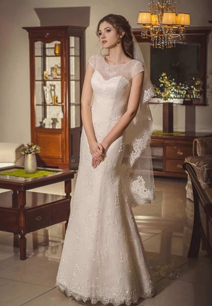 Elegante vestido de novia color marfil para mujer romántica confeccionado  en encaje con transparencias en el escote y en las mangas cortas