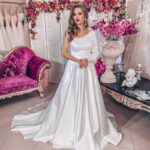 Abito da sposa in mikado dalla linea pulita monospalla con manica lunga a sbuffo e gonna lunga dalla linea A con un bellissimo strascico a cappella