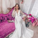 Elegant and refined slipped wedding dress enriched in transparency with many rhinestone decorations on the romantic puff sleeves