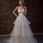 Ivory tulle wedding dress with a puffy A line effect skirt and a V-neckline with thin straps