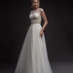 Vestido de novia Tendencias 2022 confeccionado en satèn, tul y adornos de encaje con transparencias en el busto