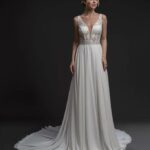 A sober and sophisticated wedding dress enhanced by the use of exclusive fabrics such as chiffon and lace with a V-neck