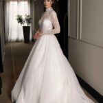 A-line dress designed with a high neckline and long lace sleeves, embellished with sequins and beads
