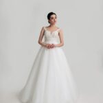 Wedding dress from the 2022 collection made with a harmonious bodice with straps and sweetheart neckline covered with embroidered lace and sparkles