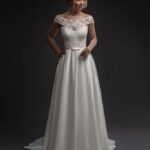 Elegant and tailored wedding dress with an unmistakable style in satin and lace with a bateau neckline and long rows of buttons on the back