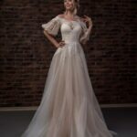 Pure romance for this wedding dress made of tulle with a fully hand-embroidered bodice with a humeral effect and half puff sleeves