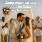 Pareja besándose en una boda en la playa de Cuba, con familiares aplaudiendo y decoración romántica.